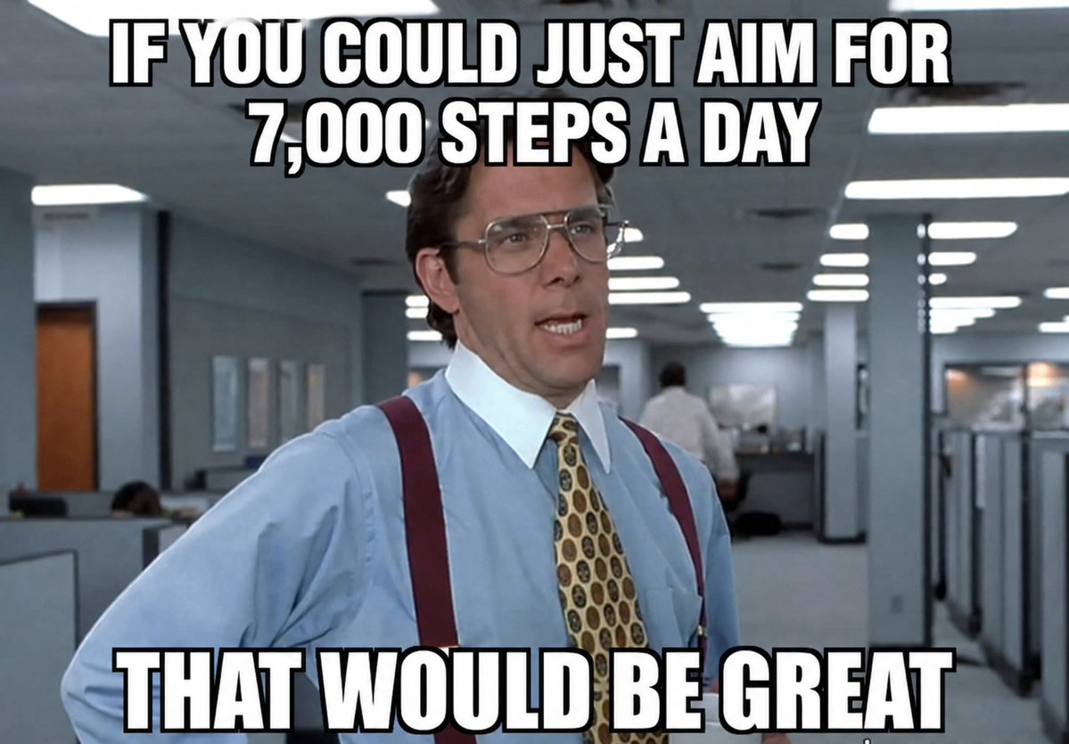 A man in a business suit speaks in an office setting, emphasizing the importance of aiming for 7,000 steps a day for health.